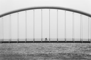 Biker crossing bridge